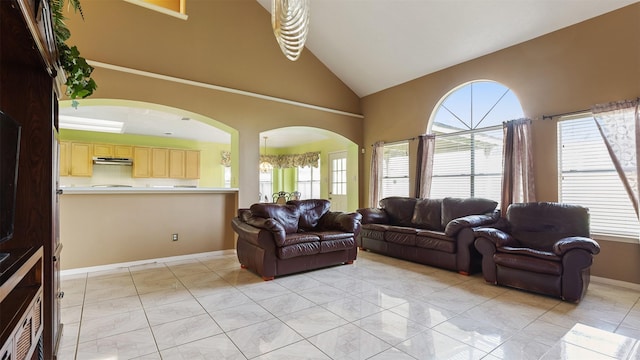 12422 Glenleigh Dr, Houston, TX 77014 - living room with healthy amount of natural light, arched walkways, light marble finish flooring, baseboards, and high vaulted ceiling