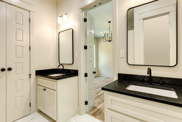 5206 4th St, Danbury, TX 77534 - full bathroom featuring marble finish flooring, a chandelier, two vanities, and baseboards