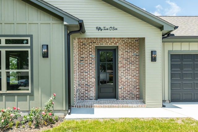 5206 4th St, Danbury, TX 77534 - entrance to property featuring board and batten siding, a garage, roof with shingles, and brick siding