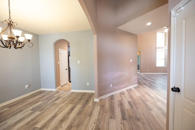 6707 Hunters Creek Ln, Baytown, TX 77521 - spare room with arched walkways, a chandelier, light wood-style flooring, baseboards, and recessed lighting