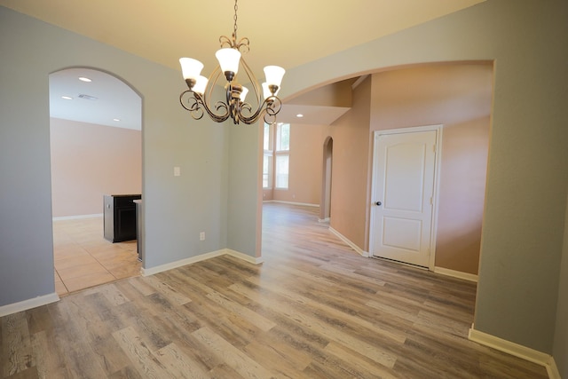 6707 Hunters Creek Ln, Baytown, TX 77521 - spare room featuring arched walkways, recessed lighting, light wood-type flooring, a chandelier, and baseboards