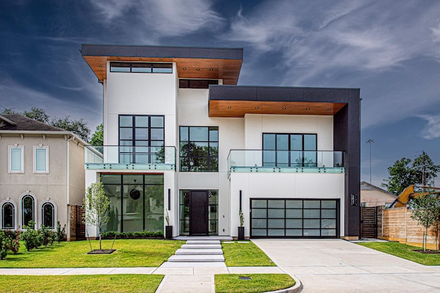 2037 Norfolk St, Houston, TX 77098 - contemporary home with a balcony, stucco siding, concrete driveway, and a garage