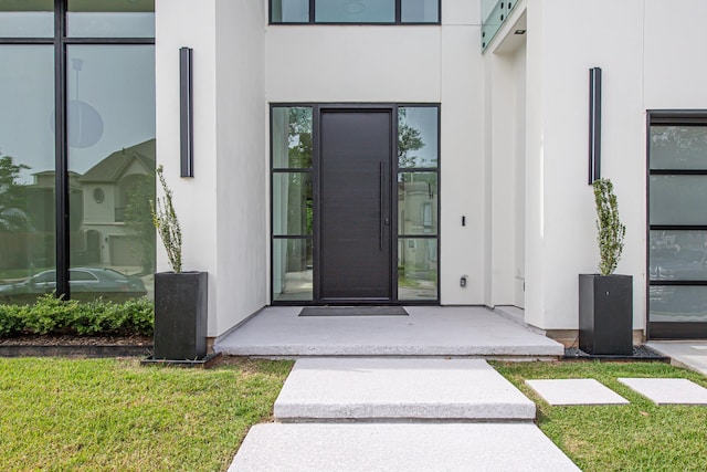 2037 Norfolk St, Houston, TX 77098 - doorway to property with stucco siding and a yard