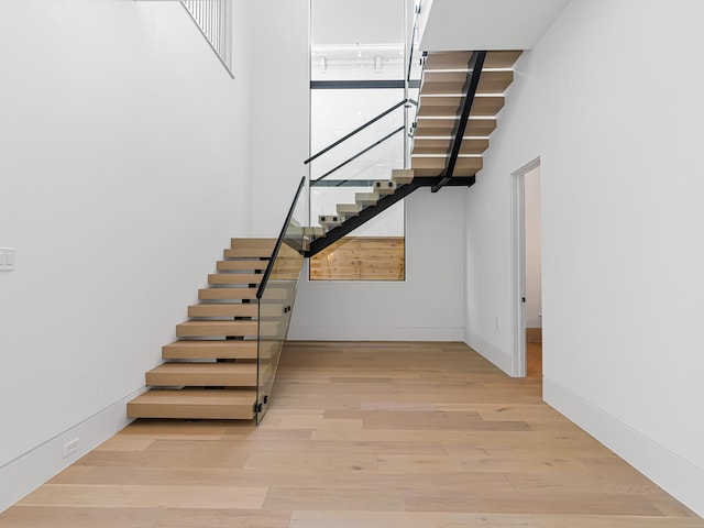 2037 Norfolk St, Houston, TX 77098 - staircase featuring wood finished floors, a high ceiling, and baseboards
