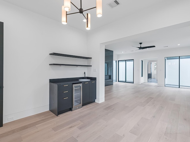 2037 Norfolk St, Houston, TX 77098 - unfurnished living room featuring wine cooler, light wood-style floors, wet bar, baseboards, and a chandelier