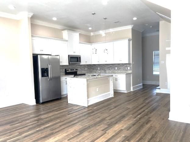 9310 Coffee St, Houston, TX 77033 - kitchen with appliances with stainless steel finishes, crown molding, white cabinets, a kitchen island with sink, and backsplash