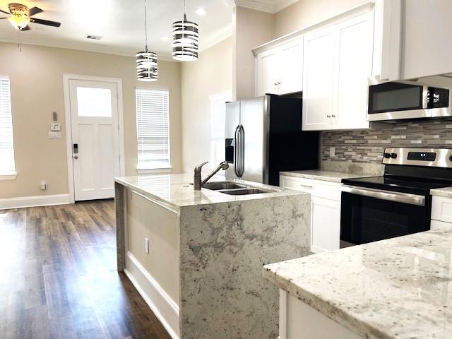 9310 Coffee St, Houston, TX 77033 - kitchen with stainless steel appliances, a sink, ornamental molding, backsplash, and dark wood-type flooring