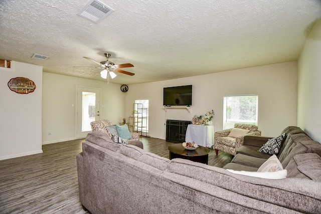 15115 Monrad Dr, Houston, TX 77053 - living area with wood finished floors, a fireplace, a textured ceiling, ceiling fan, and baseboards