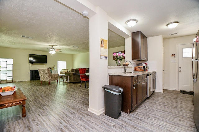15115 Monrad Dr, Houston, TX 77053 - kitchen with a textured ceiling, a sink, wood finished floors, dark brown cabinetry, and a ceiling fan