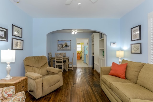 1523 22nd St, Galveston, TX 77550 - living area with a ceiling fan, arched walkways, dark wood-type flooring, and baseboards