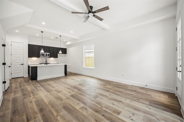 8618 Lee Otis St A-B, Unit A-B Houston, TX 77051 - kitchen with stainless steel microwave, beam ceiling, light countertops, a sink, and light wood-style flooring