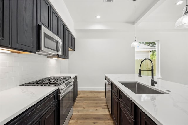 8618 Lee Otis St A-B, Unit A-B Houston, TX 77051 - kitchen featuring appliances with stainless steel finishes, a sink, decorative backsplash, recessed lighting, and light wood-type flooring