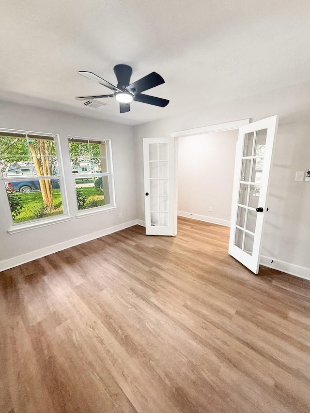 17422 Typhoon Way, Crosby, TX 77532 - empty room with french doors, baseboards, and light wood-style floors