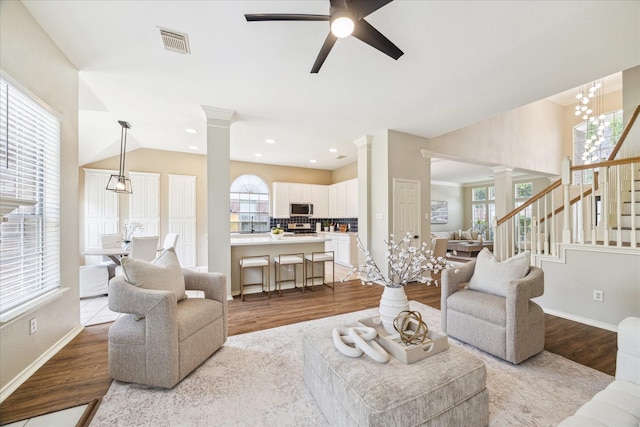 4643 Forest Home Dr, Missouri City, TX 77459 - living room with decorative columns, wood finished floors, ceiling fan, stairs, and recessed lighting