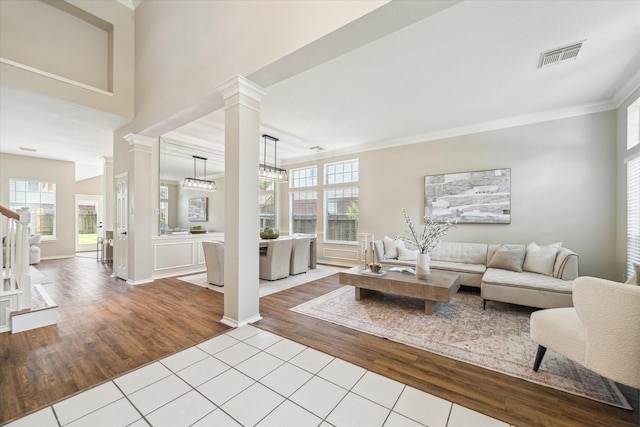 4643 Forest Home Dr, Missouri City, TX 77459 - living area featuring wood finished floors, decorative columns, crown molding, healthy amount of natural light, and stairs