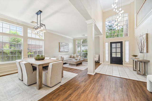 4643 Forest Home Dr, Missouri City, TX 77459 - dining space with a chandelier, wood finished floors, crown molding, decorative columns, and baseboards