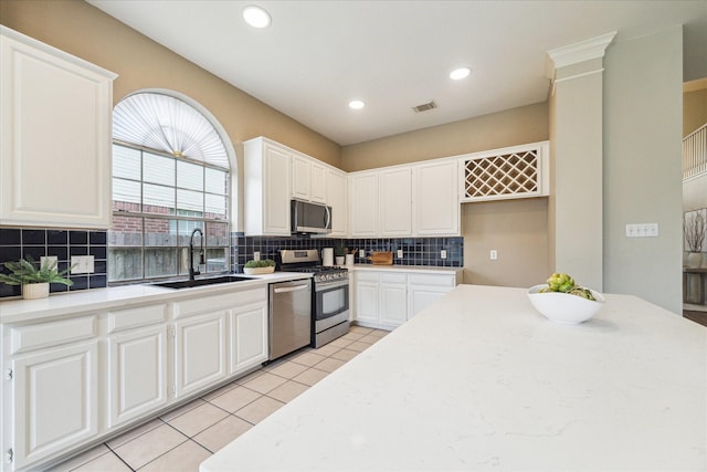4643 Forest Home Dr, Missouri City, TX 77459 - kitchen with appliances with stainless steel finishes, a sink, backsplash, white cabinets, and recessed lighting