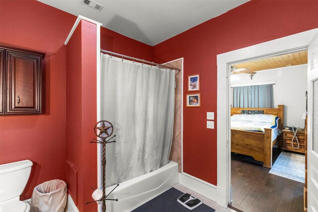 404 E Alabama St, Wharton, TX 77488 - full bath with ensuite bath, shower / tub combo with curtain, toilet, wood finished floors, and baseboards