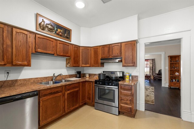 404 E Alabama St, Wharton, TX 77488 - kitchen with stainless steel appliances, a sink, under cabinet range hood, and brown cabinets