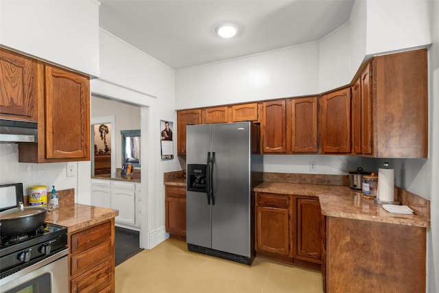 404 E Alabama St, Wharton, TX 77488 - kitchen featuring appliances with stainless steel finishes, brown cabinets, and under cabinet range hood
