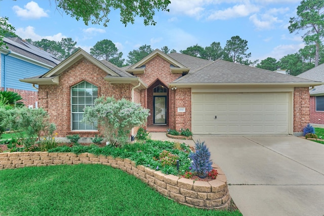 2230 Louetta Falls Ln, Spring, TX 77388 - view of front facade with concrete driveway, brick siding, a garage, a front yard, and a shingled roof