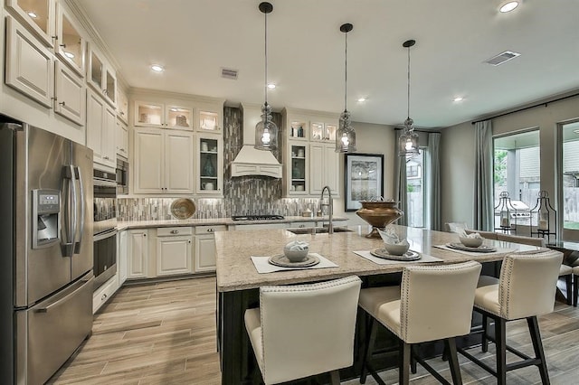29506 Highland Manor Ct, Katy, TX 77494 - kitchen with stainless steel appliances, a sink, a kitchen breakfast bar, decorative light fixtures, and decorative backsplash