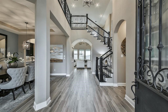 29506 Highland Manor Ct, Katy, TX 77494 - foyer entrance featuring stairway, baseboards, a chandelier, wood finished floors, and arched walkways