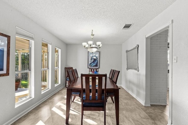 2505 Gerol Dr, Galveston, TX 77551 - dining area featuring a chandelier, a textured ceiling, and baseboards