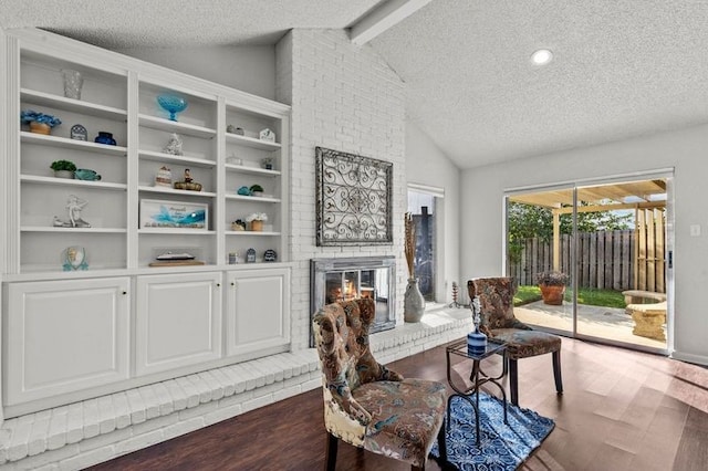 2505 Gerol Dr, Galveston, TX 77551 - living area with a textured ceiling, wood finished floors, a fireplace, and built in features
