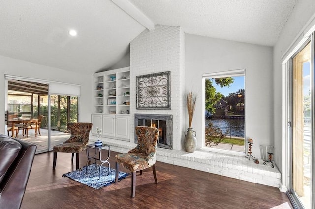 2505 Gerol Dr, Galveston, TX 77551 - living area with wood finished floors, a brick fireplace, and a textured ceiling