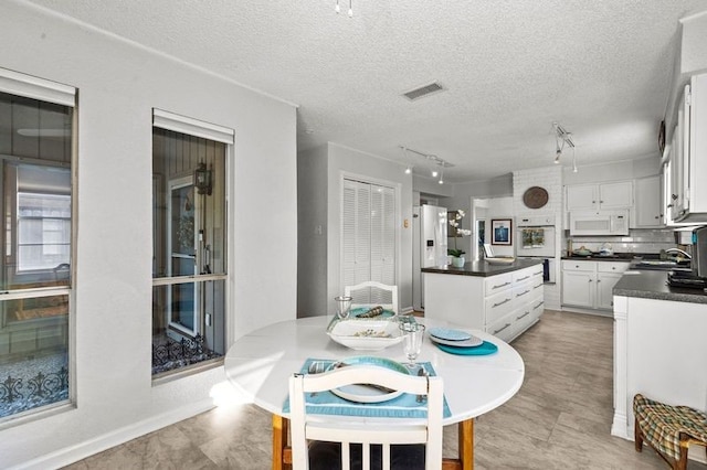 2505 Gerol Dr, Galveston, TX 77551 - dining room featuring rail lighting and a textured ceiling