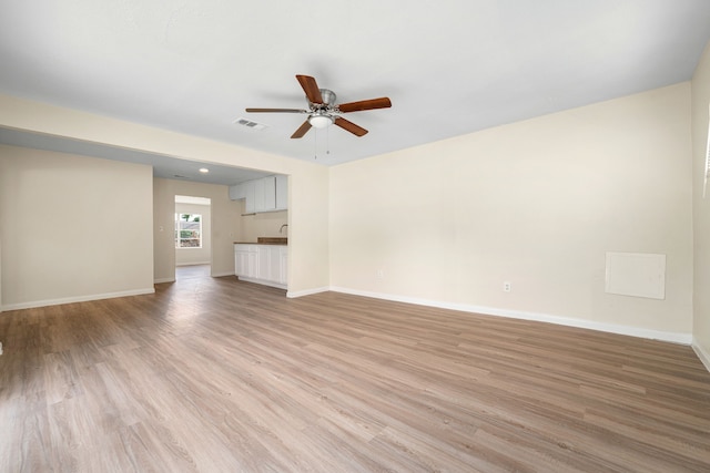 4726 Angleton St, Houston, TX 77033 - unfurnished living room featuring ceiling fan, light wood-style flooring, and baseboards