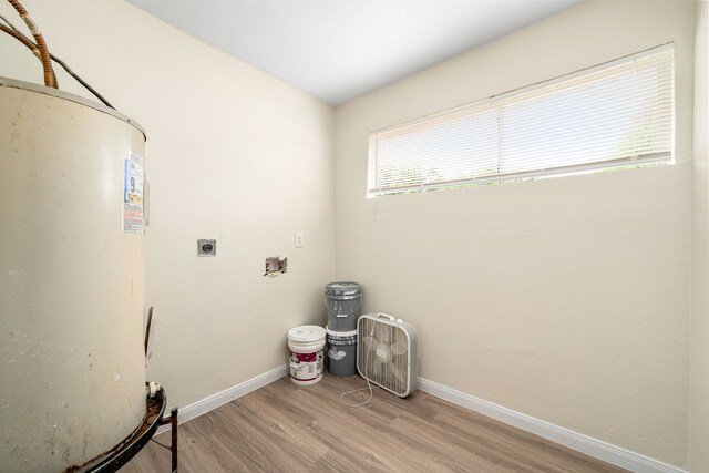 4726 Angleton St, Houston, TX 77033 - laundry room with electric dryer hookup, gas water heater, light wood finished floors, baseboards, and hookup for a washing machine