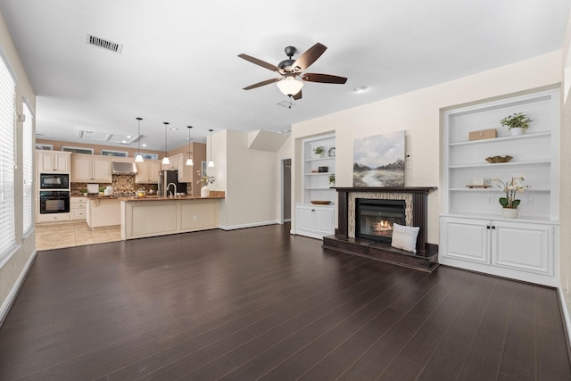 62 Treescape Cir, The Woodlands, TX 77381 - living room with a glass covered fireplace, ceiling fan, wood finished floors, and baseboards