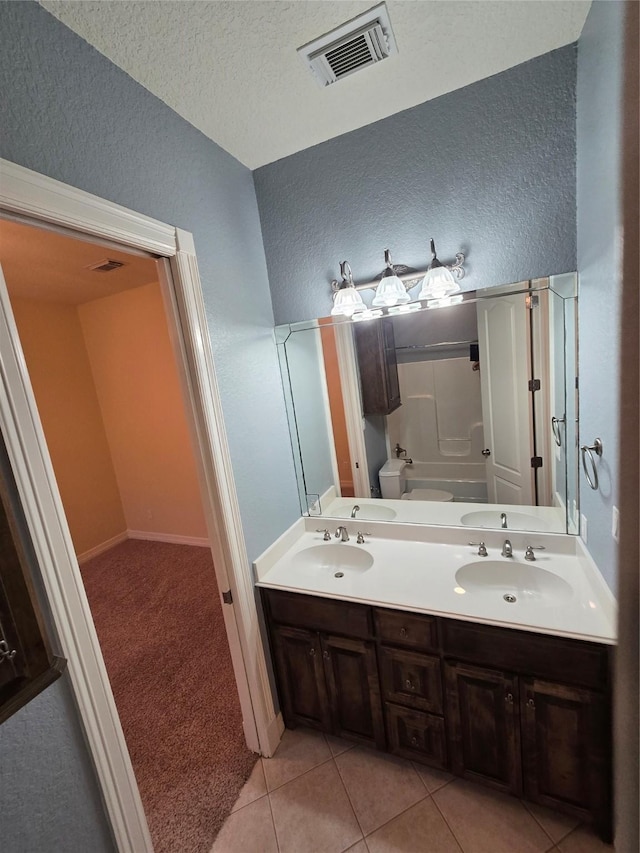 1008 Heritage Oaks Dr, Angleton, TX 77515 - full bath featuring a textured wall, toilet, tile patterned flooring, double vanity, and a shower