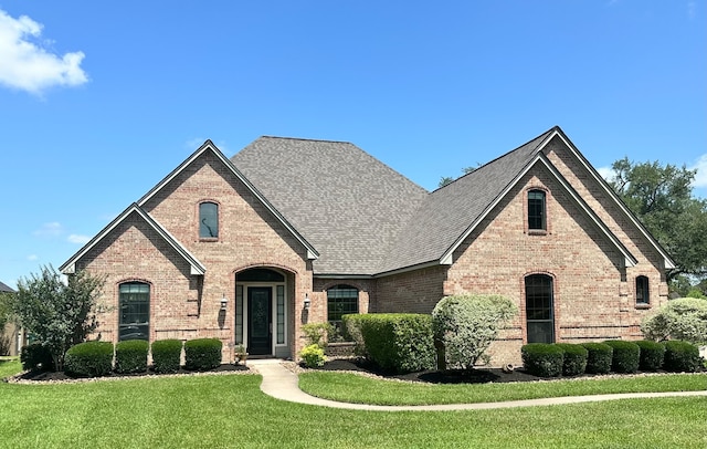 1008 Heritage Oaks Dr, Angleton, TX 77515 - french country style house with brick siding, a front lawn, and a shingled roof