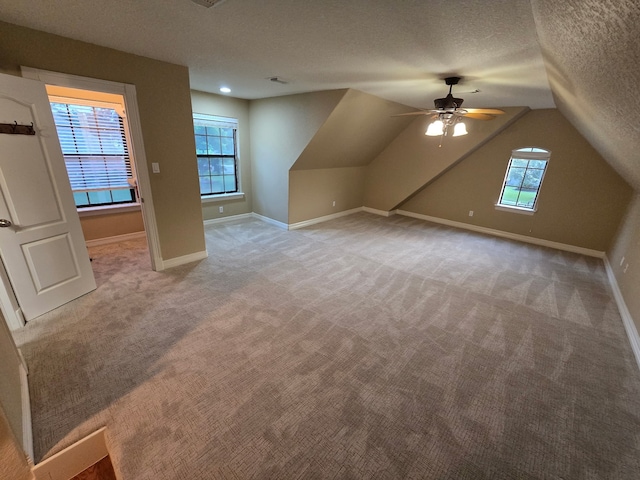 1008 Heritage Oaks Dr, Angleton, TX 77515 - additional living space with ceiling fan, light carpet, a textured ceiling, baseboards, and lofted ceiling