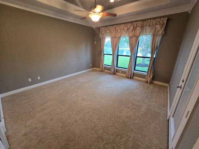 1008 Heritage Oaks Dr, Angleton, TX 77515 - spare room featuring ornamental molding, baseboards, ceiling fan, light colored carpet, and a tray ceiling