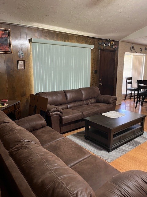 5363 Marian St, Katy, TX 77493 - living area featuring wood finished floors, a textured ceiling, and wooden walls