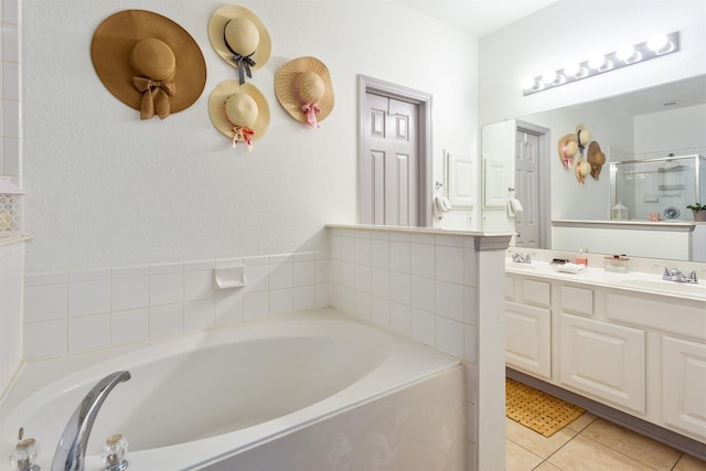 17218 Marquette Point Ln, Humble, TX 77346 - bathroom featuring a garden tub, double vanity, tile patterned floors, and a shower with door