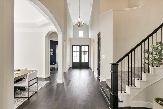 18115 Bachman Branch Dr, Cypress, TX 77433 - entryway featuring a chandelier, a high ceiling, stairs, dark wood-type flooring, and arched walkways