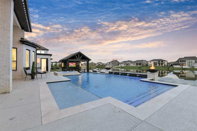 18115 Bachman Branch Dr, Cypress, TX 77433 - pool at dusk with a gazebo, a patio area, a pool with connected hot tub, and a residential view