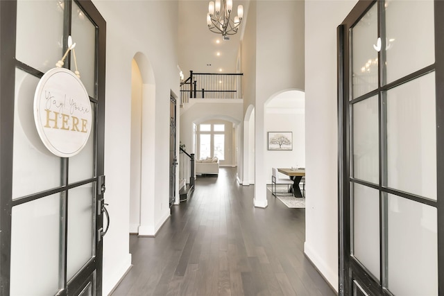 18115 Bachman Branch Dr, Cypress, TX 77433 - entrance foyer with arched walkways, a towering ceiling, baseboards, dark wood-style floors, and a chandelier