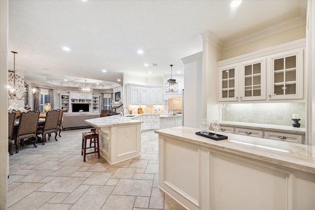 10250 Clubhouse Cir, Magnolia, TX 77354 - kitchen featuring a sink, open floor plan, stone tile floors, decorative backsplash, and light stone countertops