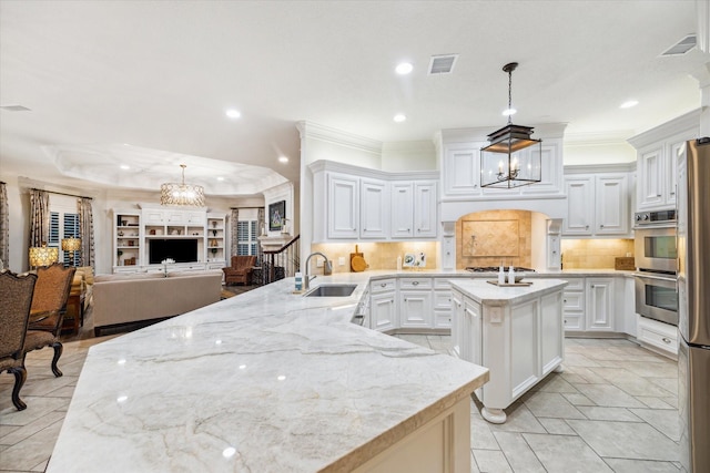 10250 Clubhouse Cir, Magnolia, TX 77354 - kitchen with a chandelier, a sink, a kitchen island with sink, backsplash, and recessed lighting