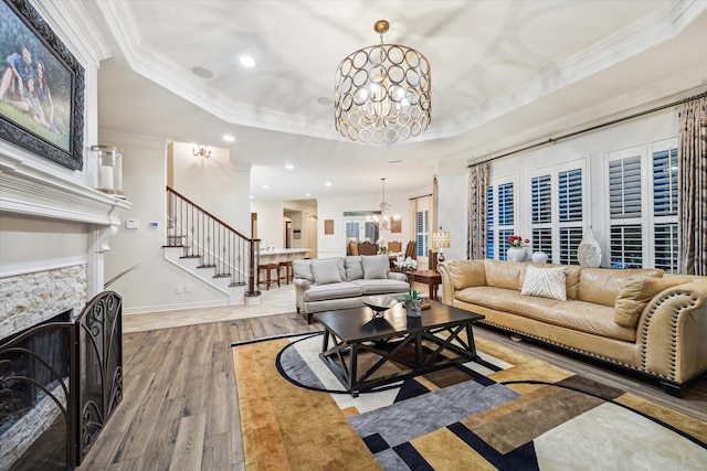 10250 Clubhouse Cir, Magnolia, TX 77354 - living area featuring a chandelier, a tray ceiling, hardwood / wood-style flooring, crown molding, and a fireplace