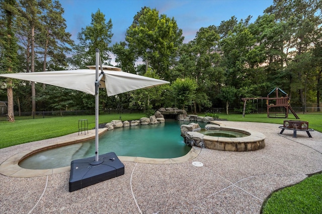 10250 Clubhouse Cir, Magnolia, TX 77354 - view of pool featuring a playground, a pool with connected hot tub, view of wooded area, and a patio area