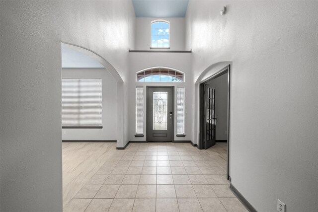 13909 Stonewood Ct, Rosharon, TX 77583 - entrance foyer featuring tile patterned flooring, baseboards, arched walkways, and a towering ceiling