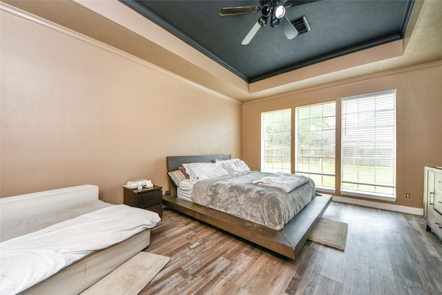 23214 Gatecreek Ct, Katy, TX 77494 - bedroom featuring a tray ceiling, wood finished floors, ornamental molding, baseboards, and a ceiling fan