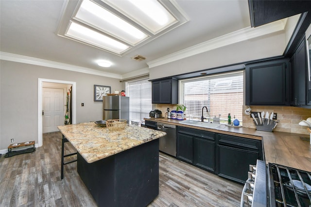 23214 Gatecreek Ct, Katy, TX 77494 - kitchen with a sink, stainless steel appliances, ornamental molding, a breakfast bar, and a center island